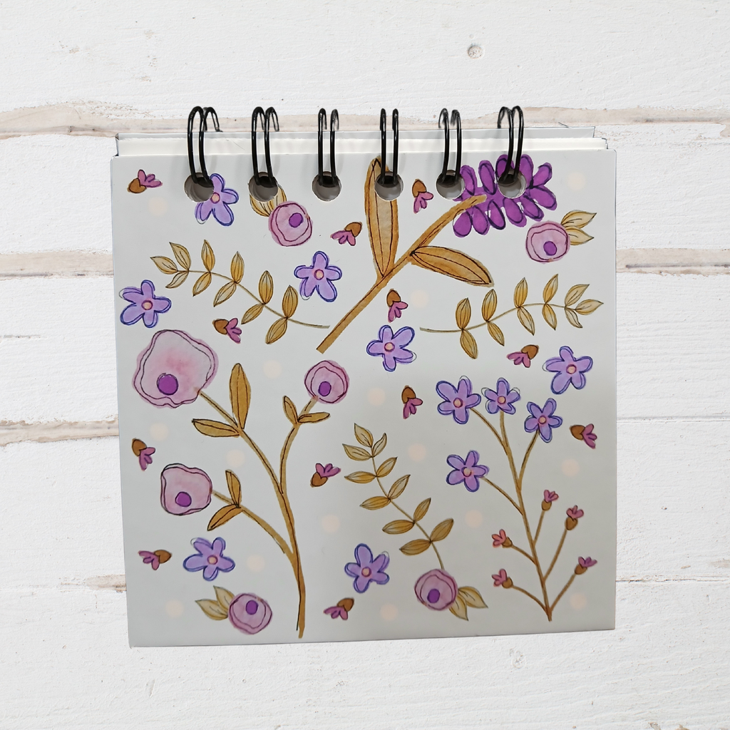 Notebook with floral design on a wooden surface