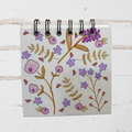 Notebook with floral design on a wooden surface