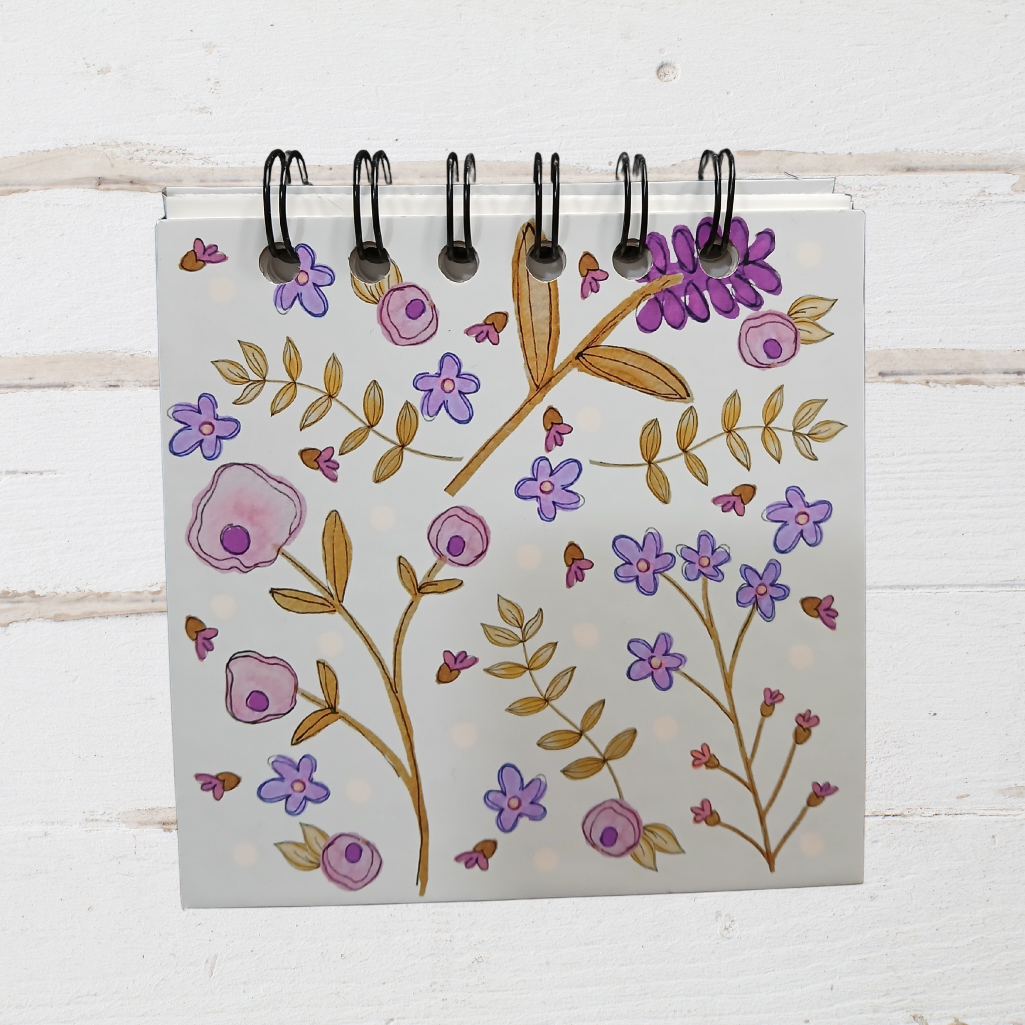 Notebook with floral design on a wooden surface