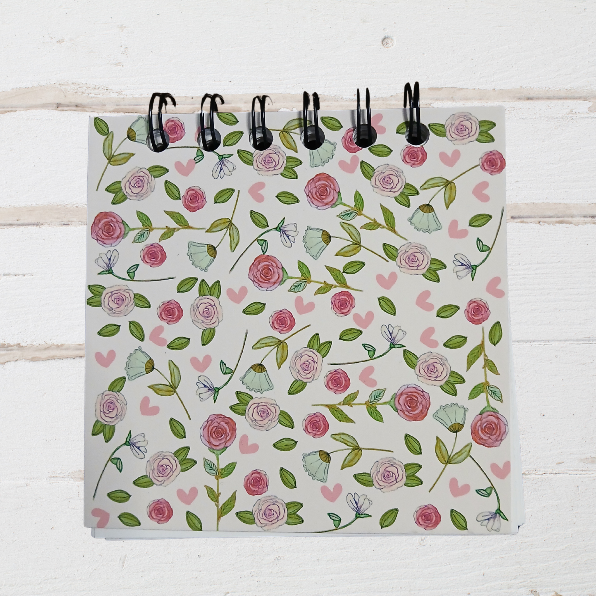 Notebook with floral pattern on a white wooden surface