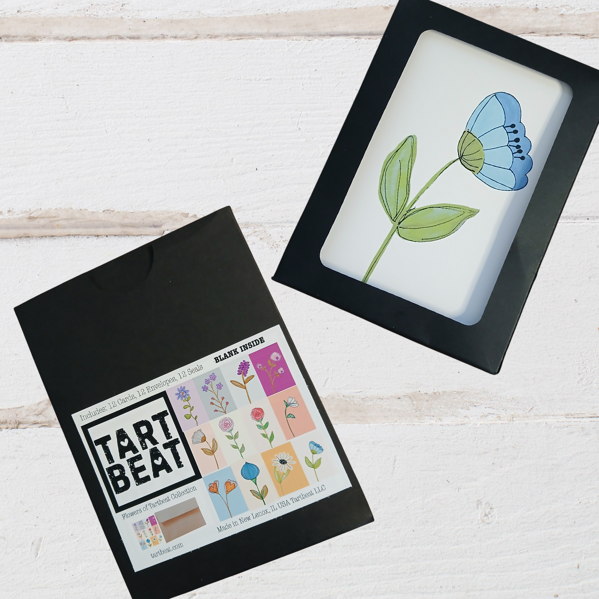 Framed artwork of a blue flower on a white background, next to a black box labeled 'Tart Beat'.