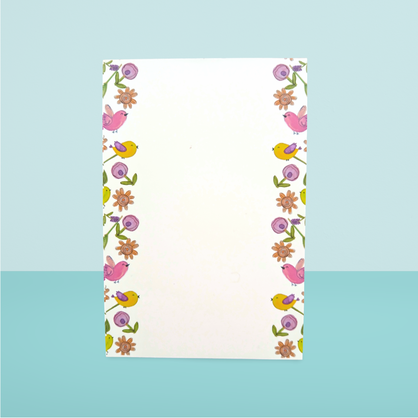 Notepad with floral and bird pattern on a light blue background