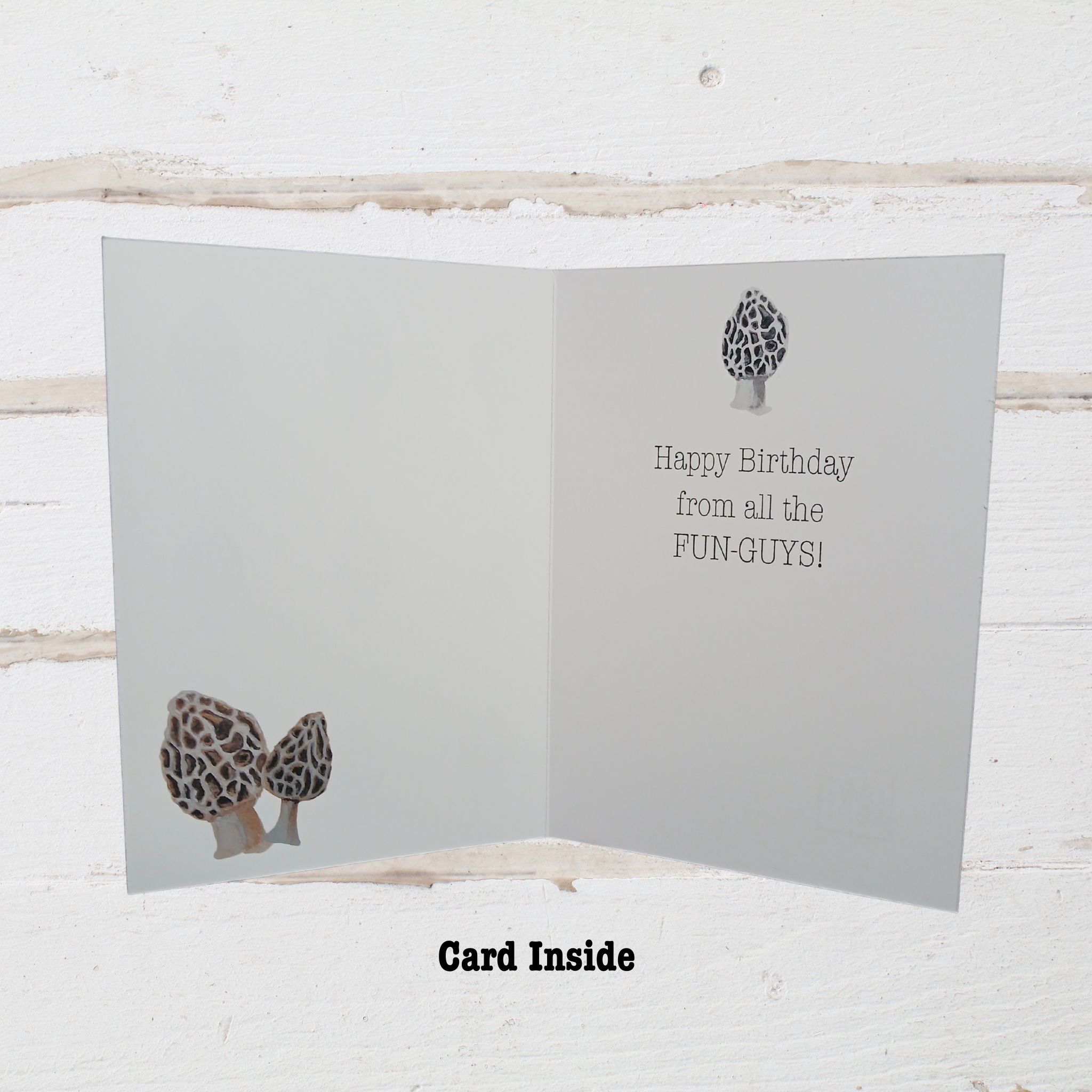 Greeting card with mushroom illustrations and text on a wooden surface