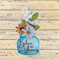 Decorative sticker with flowers and 'Believe in Yourself' text on a wooden background