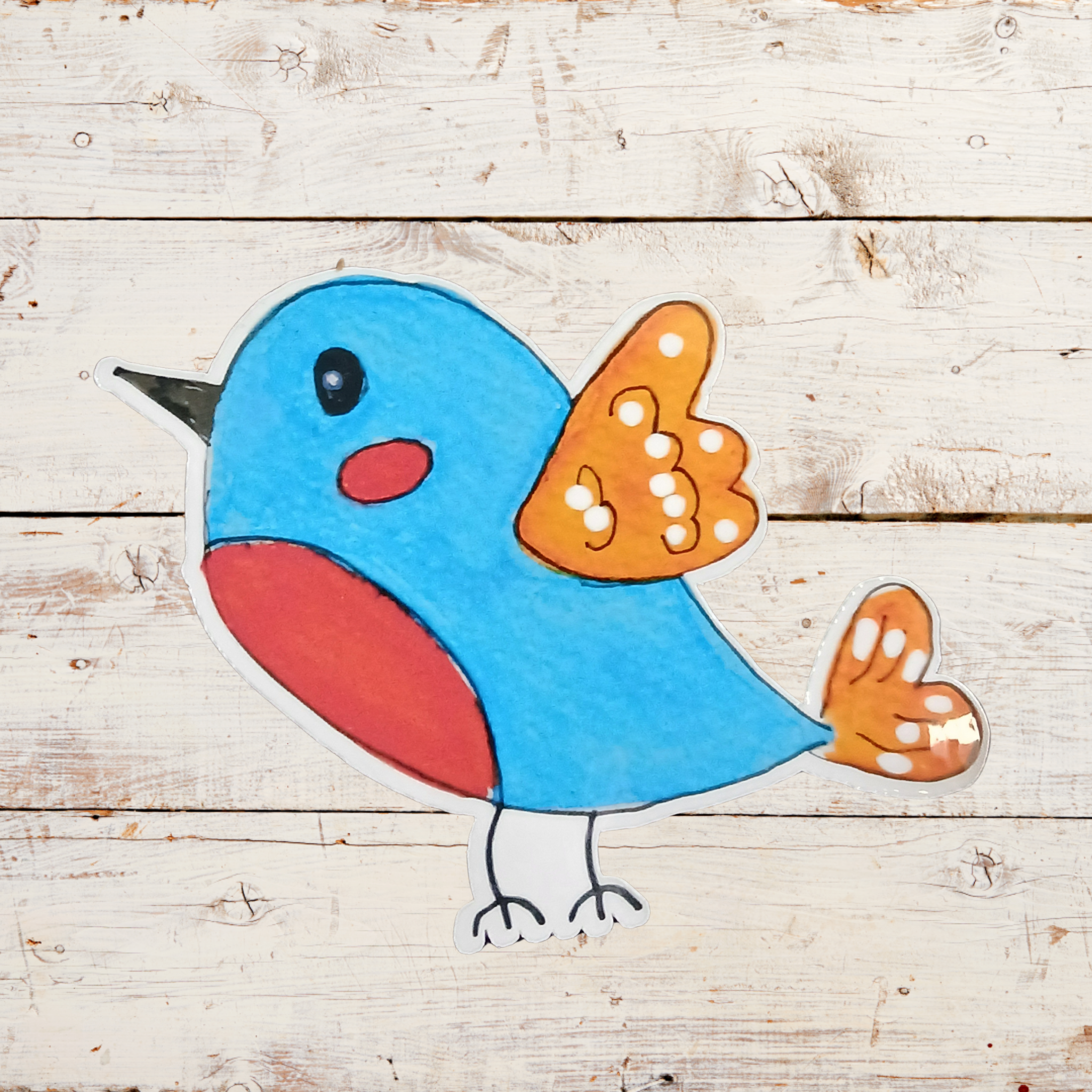 Colorful bird sticker on a wooden background