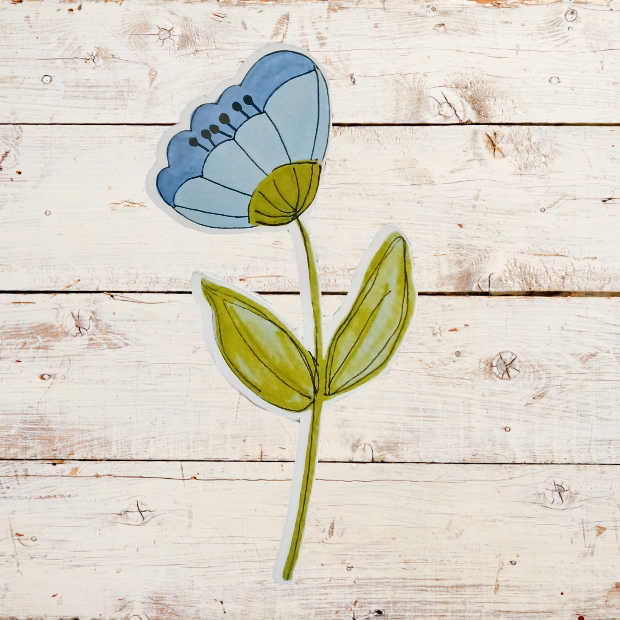 Stylized blue flower with green stem and leaves on a wooden surface