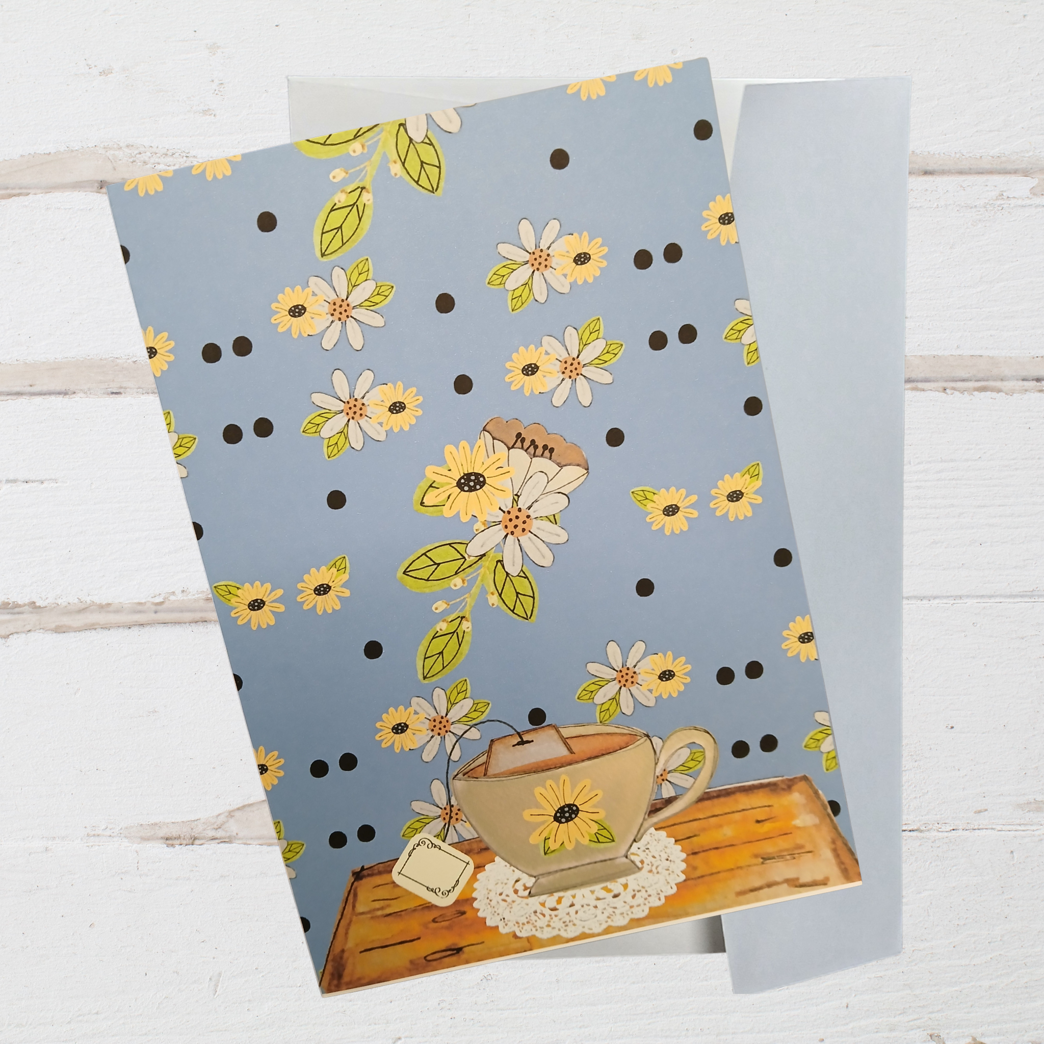 Floral patterned paper with a teacup design on a wooden surface