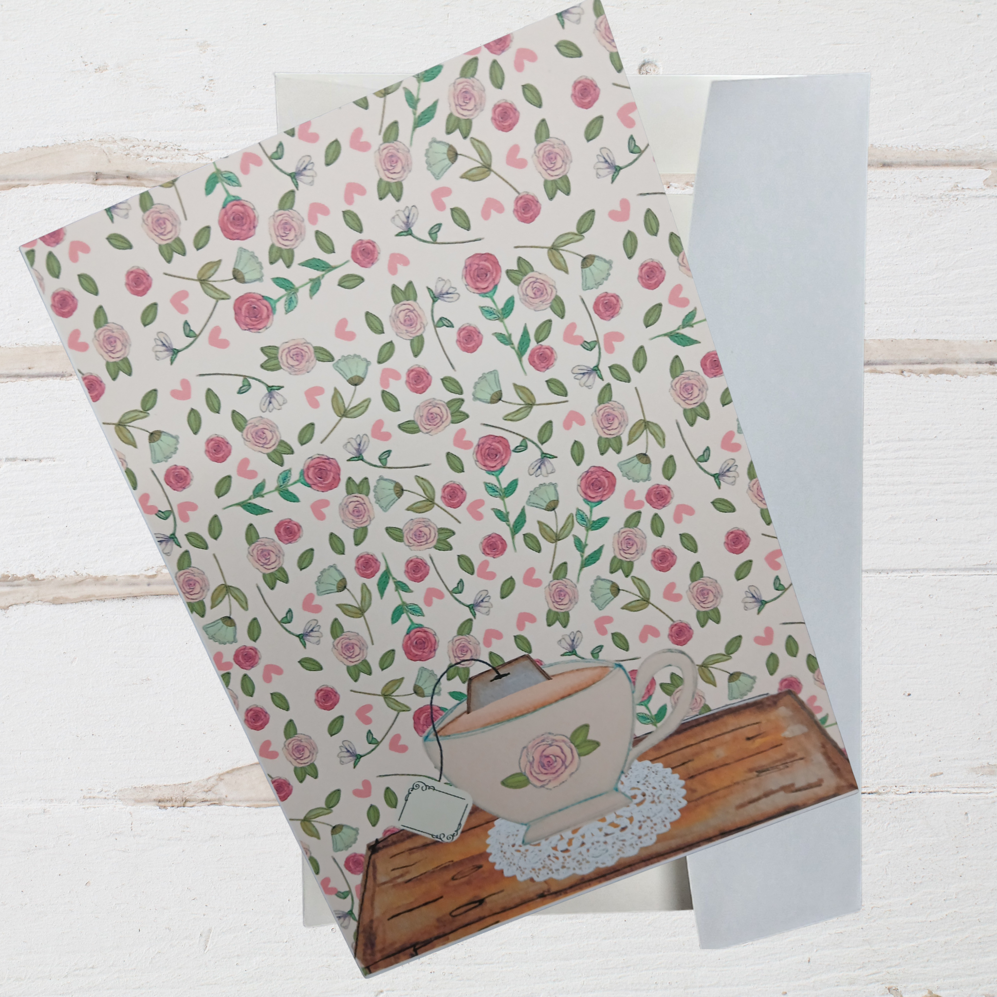 Floral patterned paper with a teapot design on a wooden surface