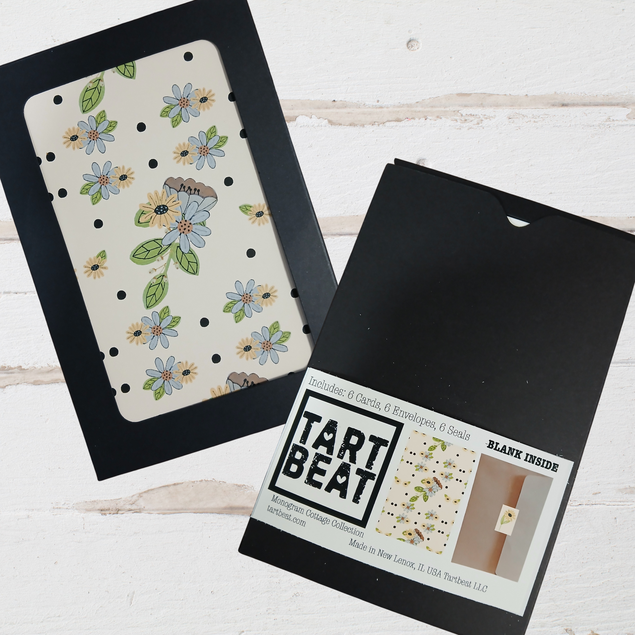 Floral patterned card with black border and 'Tart Beat' packaging on a white wooden surface