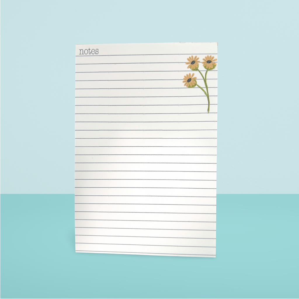 Notepad with floral design on a light blue background