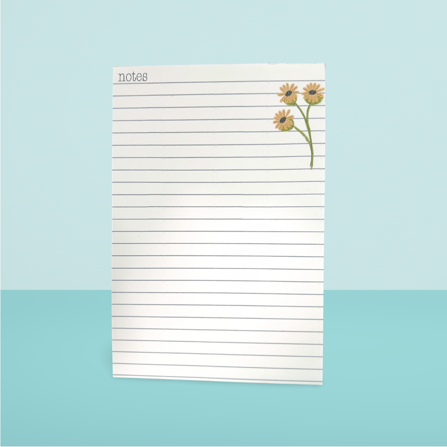 Notepad with floral design on a light blue background