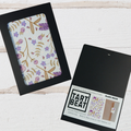 Floral notebook with black frame and 'Tart Beat' packaging on a light wooden surface