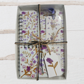 Floral notebook and card set with decorative ribbon on a white wooden surface