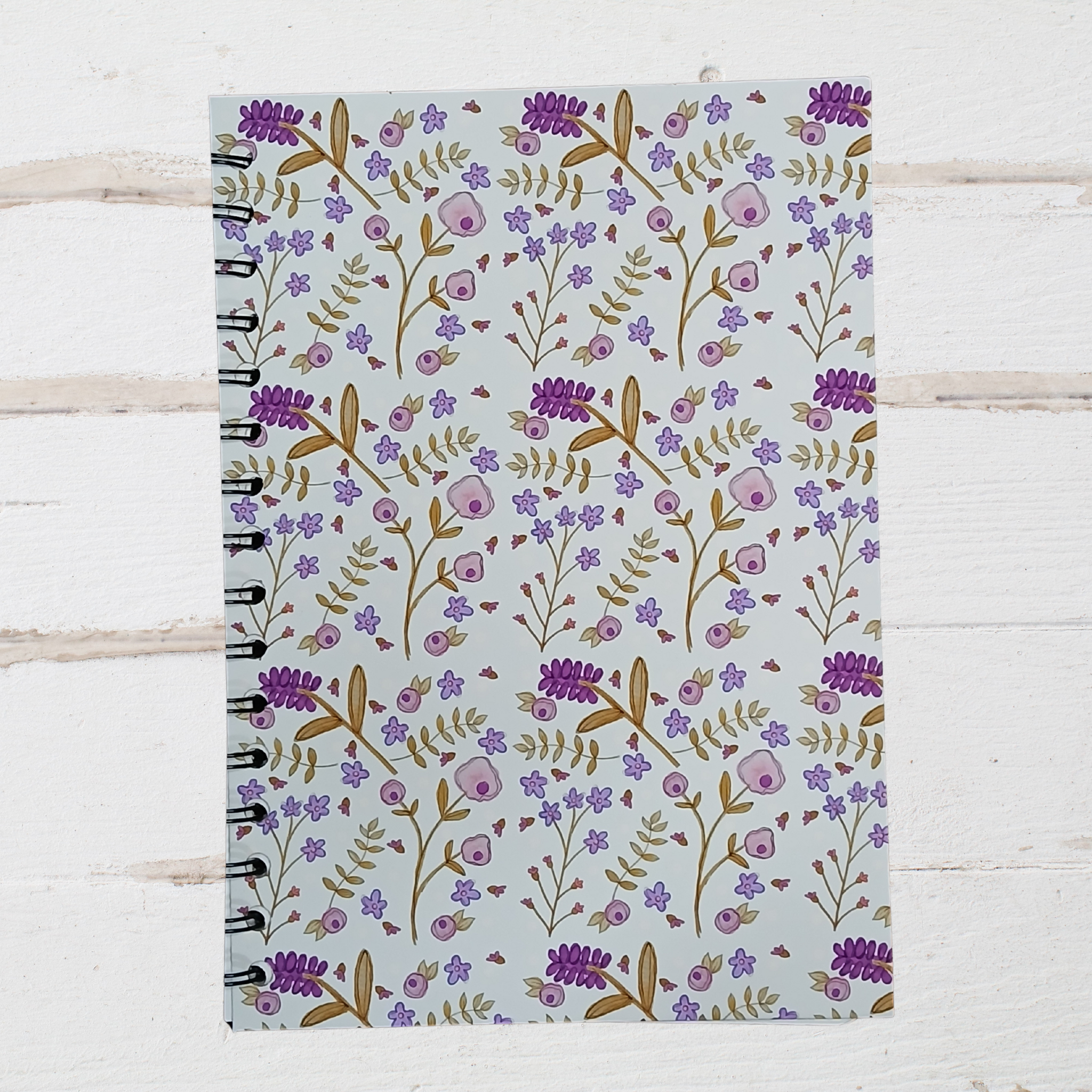 Notebook with floral pattern on a wooden surface