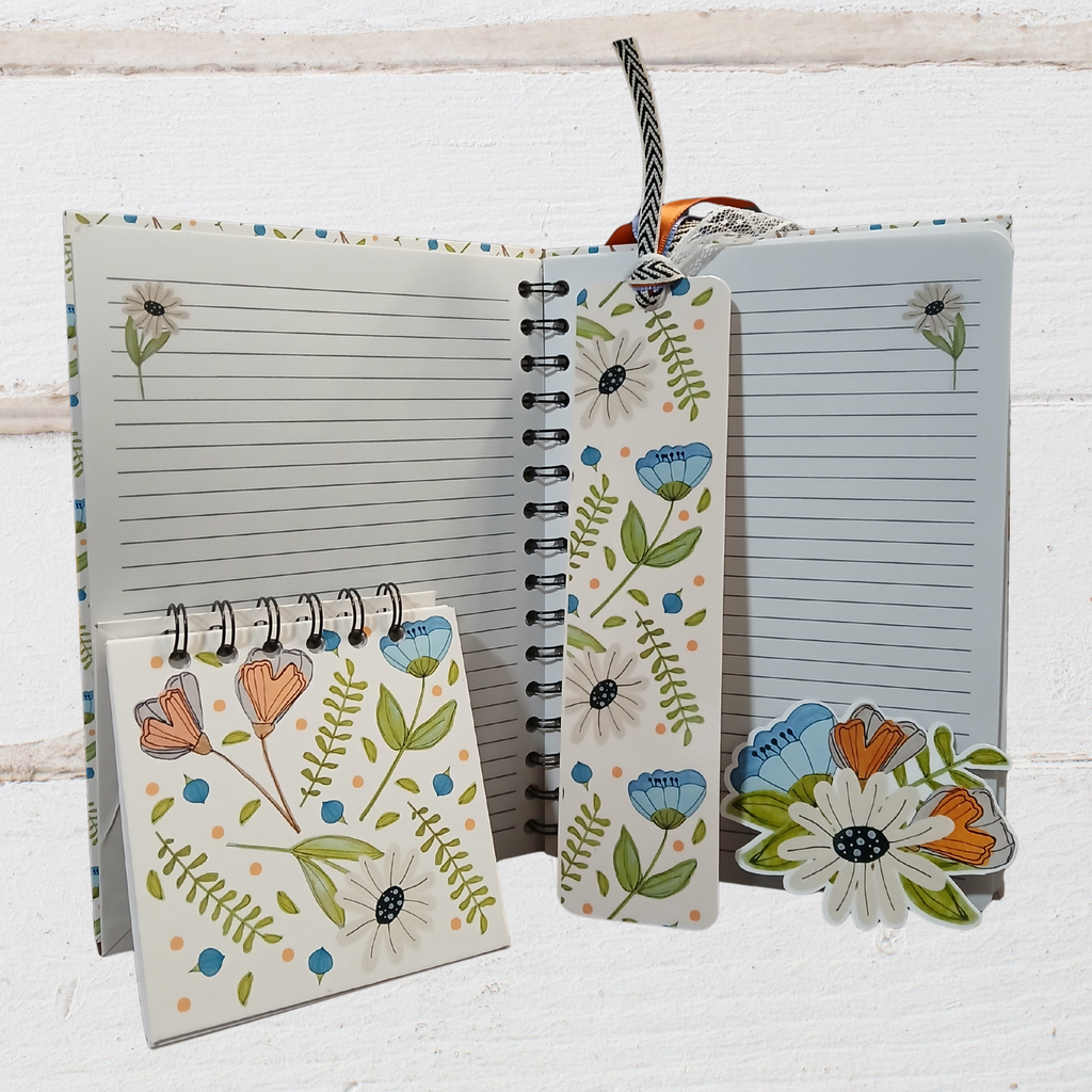 Notebook with floral designs on a white wooden background