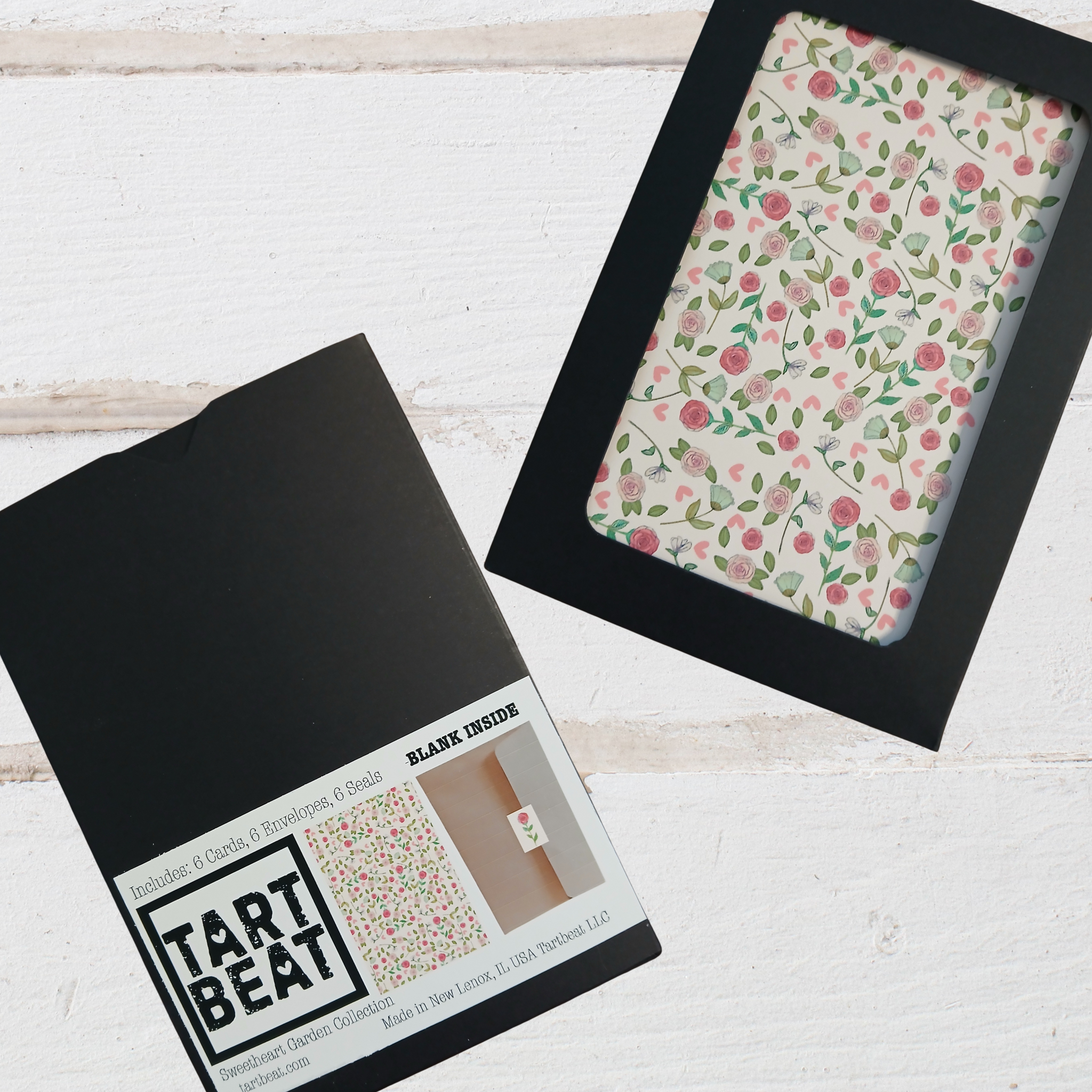 Floral notebook cover with black packaging on a light wooden surface