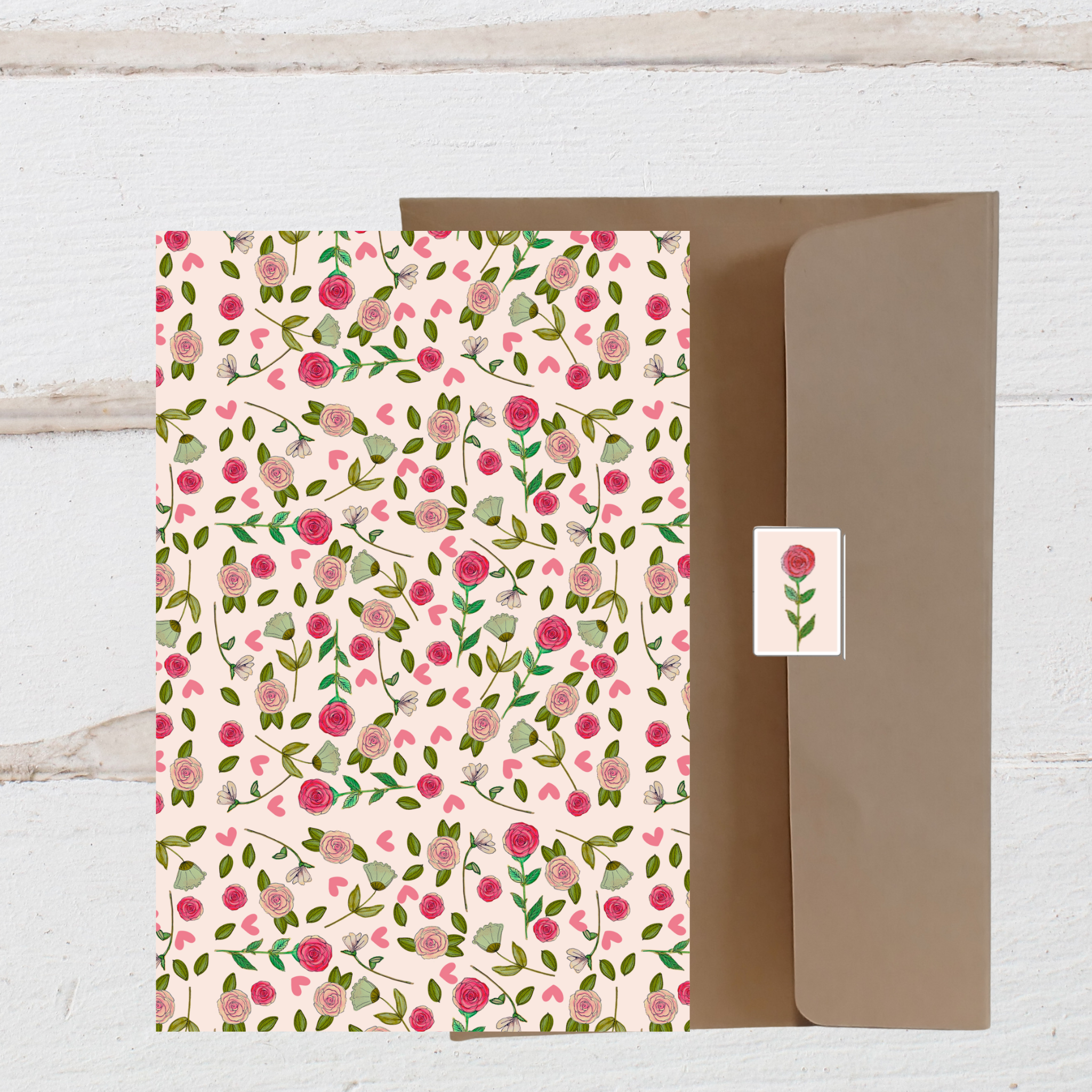 Floral patterned paper with a matching card on a wooden surface