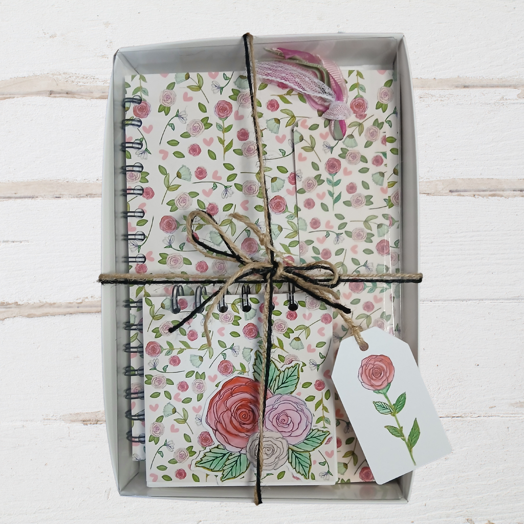 Floral notebook set with decorative paper and twine on a white wooden surface