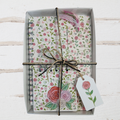 Floral notebook set with decorative paper and twine on a white wooden surface