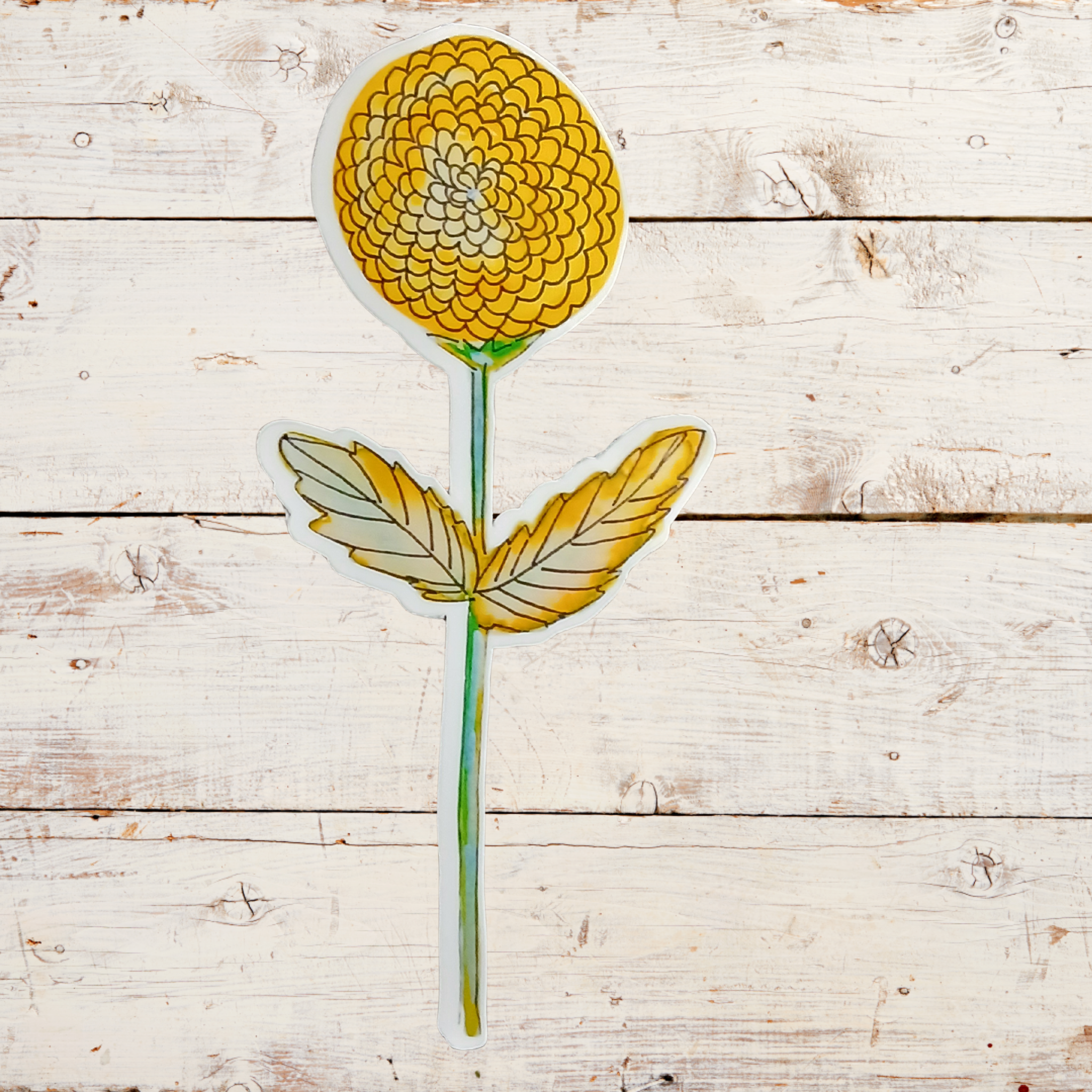 Yellow flower-shaped object on a wooden surface